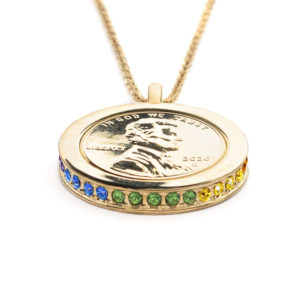 Side view of the Promise, Wear to Evoke Hope pendant and necklace with plated US penny set into a 22 carat band edged with sparkling Iridescent Rainbow-Swarovski crystals.