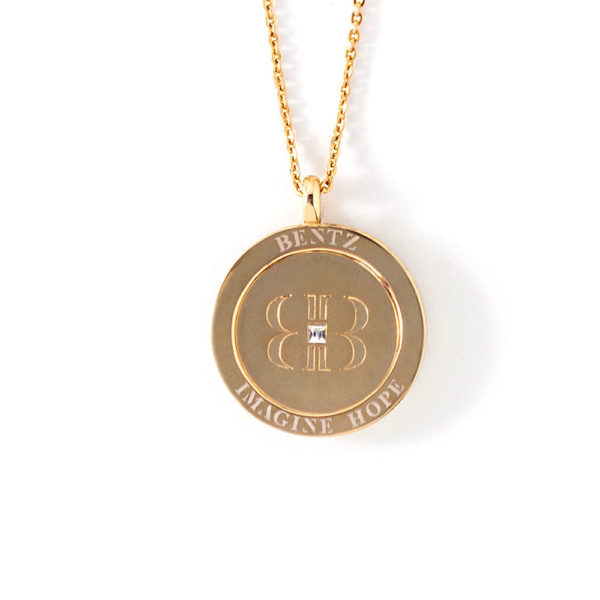 Back view of the Promise, Wear to Evoke Hope pendant and necklace with Bentz engraved on band top and Imagine Hope on bottom. The back of the penny has the BB signature logo, mirrored letter B’s joined with a clear crystal.