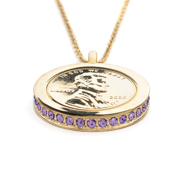 Side view of the Royalty, Wear to Evoke Spirituality pendant and necklace with plated US penny set into a 22 carat band edged with sparkling, Iris Violet-Swarovski crystals.