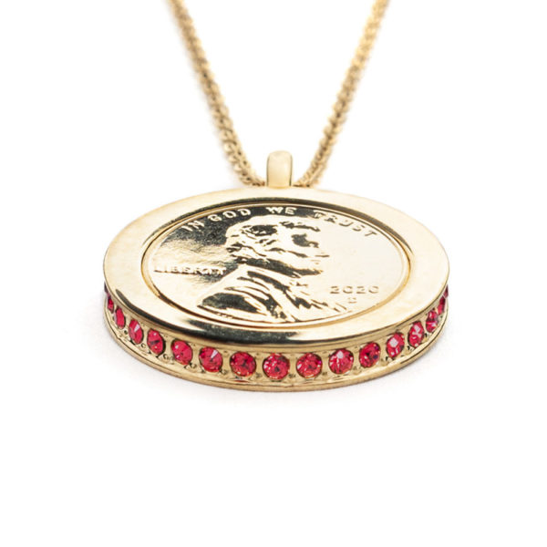 Side view of the Vermilion, Wear to Evoke Passion pendant and necklace with plated US penny set into a 22 carat band edged with sparkling, Scarlet Red-Swarovski crystals.