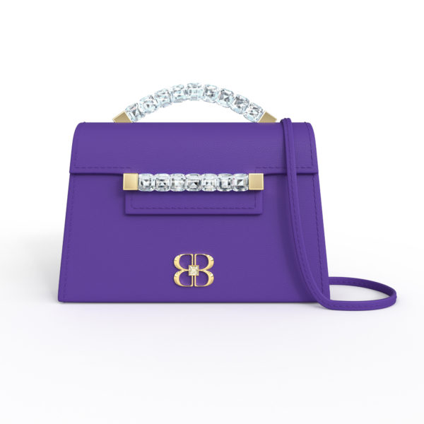 Front view of royal purple Baby Jewel Crossbody bag with a tapered trapezoidal shape, clear Swarovski crystal top handle and front strap, yellow gold hardware, yellow gold and crystal BB plaque, and matching purple detachable shoulder strap.